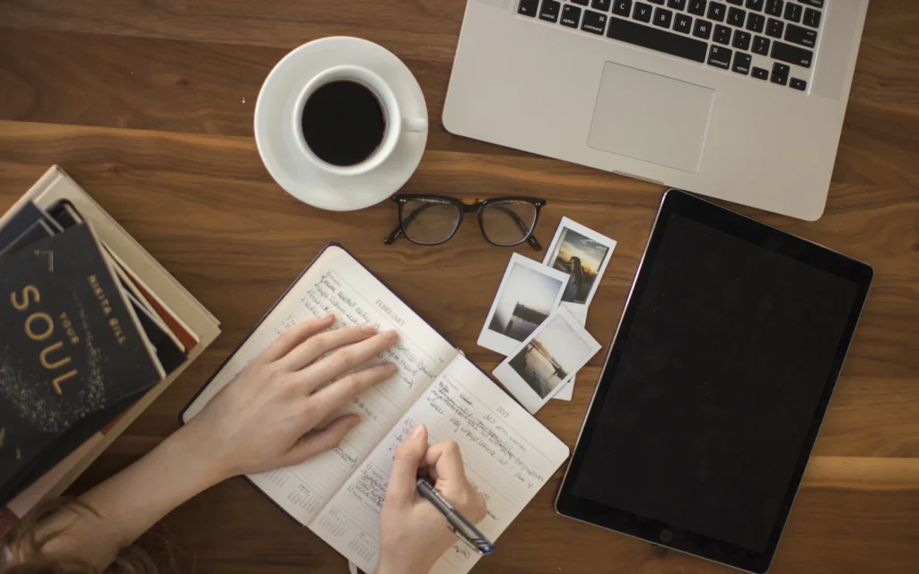 Author writing at a desk, the person behind good author website design