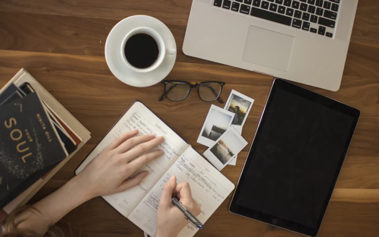 Author writing at a desk, the person behind good author website design