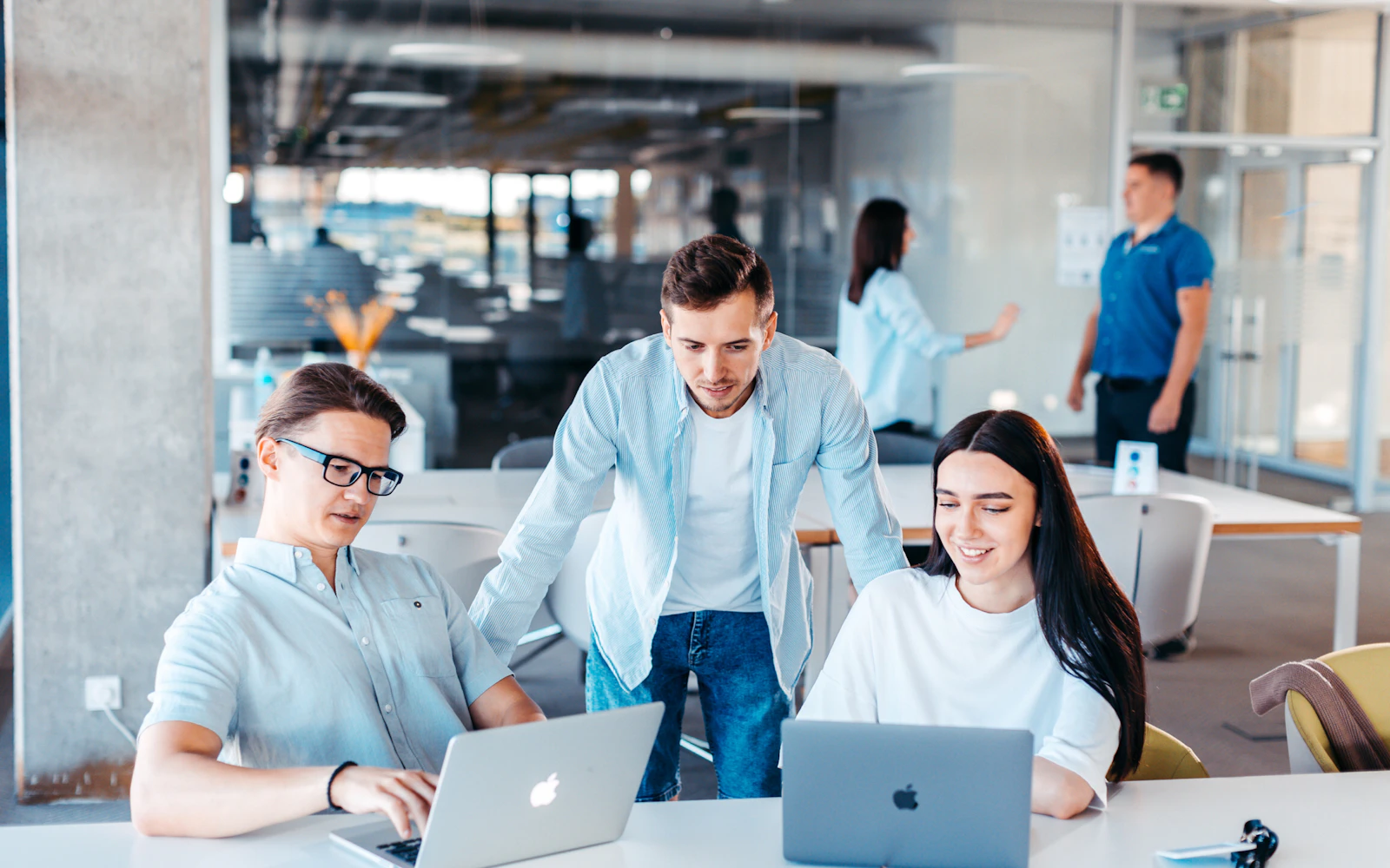 Small team reviewing templates together around a laptop