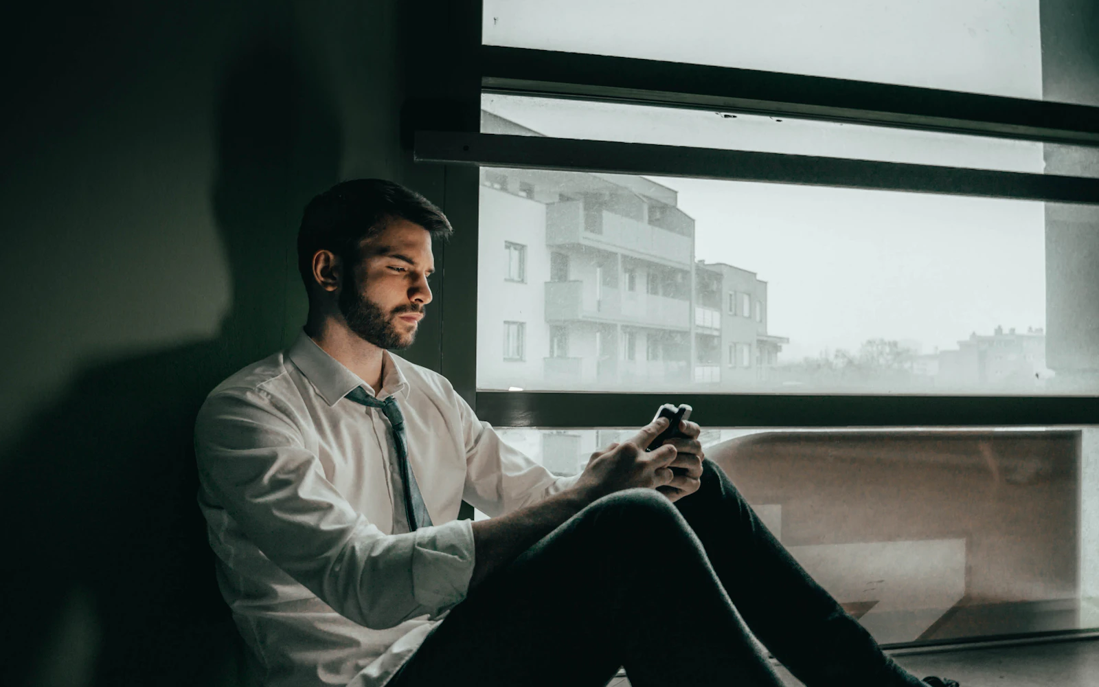 Reader checking a newsletter on his phone by the window