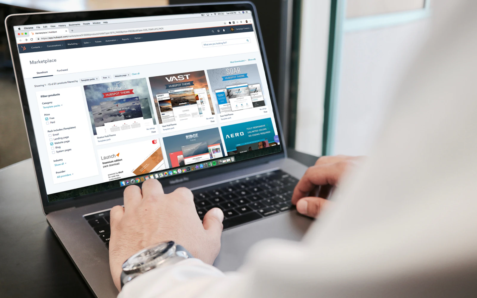 Consultant reviewing a new homepage on a laptop in an office