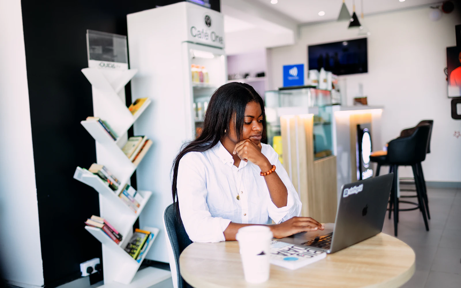 Professional reading a consultant profile on a laptop in a cafe