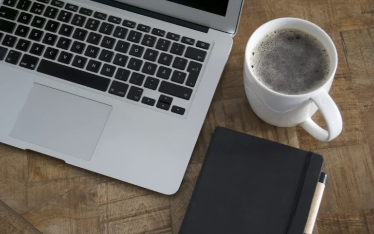 Laptop and coffee set up for planning a weekly LinkedIn content strategy