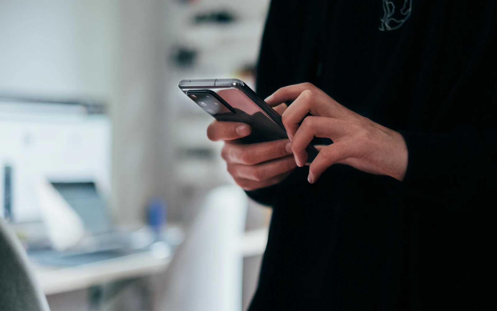 Professional checking a LinkedIn profile on a phone before a meeting