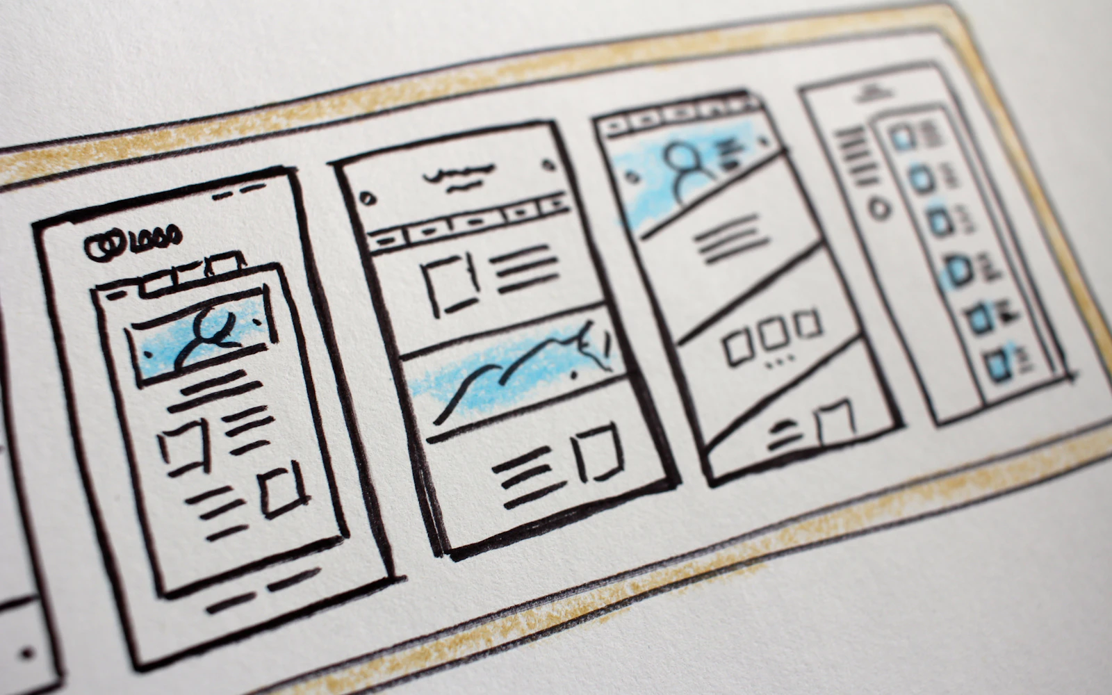 Website redesign checklist next to wireframe sketches on a designer's desk